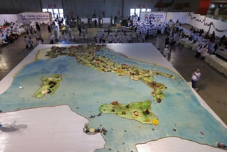 A giant cake baked in Italy that measures over 16 metres long and weighs more than 1,000 kg has set the world record for the world's largest cake sculpture. The cake, measuring 16.46 metres long by 13.94 metres wide, was decorated with a map of Italy and its most famous landmarks, including the Leaning Tower of Pisa and the Alps. The cake had a total surface area of 244 square metres and weighed more than a tonne (1,000 kg). 
